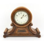 Oak presentation mantel clock 21.5 cm high and an oval wall mirror, 47 x 75 cm (2)
