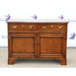 Oak side cabinet, with two frieze drawers, slide and two panelled doors on bracket feet,