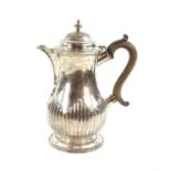 Silver jug with half-reeded decoration the cover with urn finial, wood handle, with cancelled