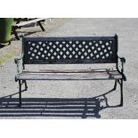 Green cast iron and teak garden bench, the lattice back over scroll arms and legs, H77 W128 cm