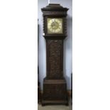 Carved oak eight day longcase clock, the caddy hood top with barley twist columns enclosing a brass
