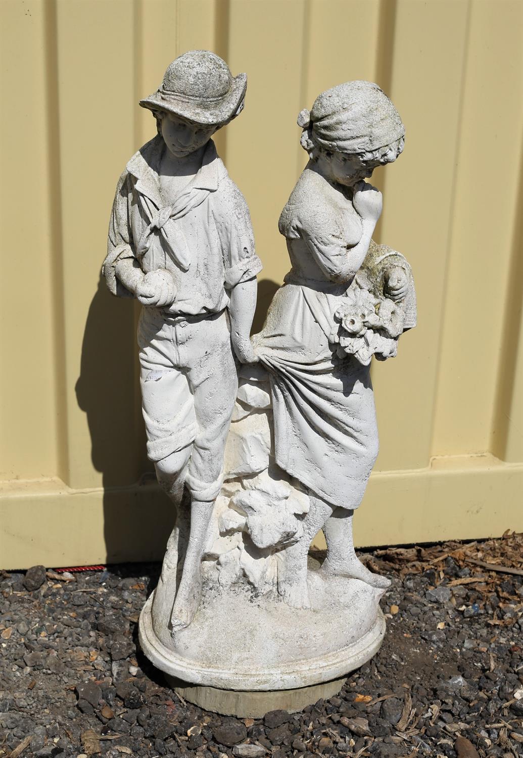 Reconstituted stone figure group of two figuresl, the boy holding the back of the girl's skirt,
