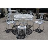 White painted aluminium garden table and four chairs, of foliate and scroll design,