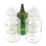 Six one-gallon glass demijohn jars, together with two green glass jars, tallest is 37cm.