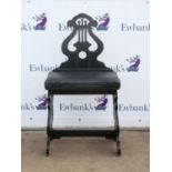 Ebonised pipe organ stool, the lyre shape back with overstuffed seat on lyre shape supports,