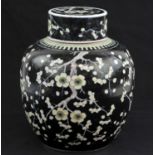 A Chinese Famille Noire Jar with Cover. Qing dynasty. Painted with flowering prunus design,