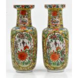 A pair of Chinese yellow ground Famille Rose vases, 19/20th century. Painted with panels with