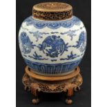 A Blue and White Phoenix Jar with Wooden Lid and Cover painted around the body in inky cobalt tones