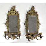 Pair of gilt brass girandole, the bevelled rectangular plates surmounted by cherubs leaning on a