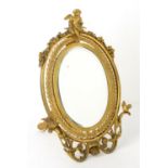 Early 20th century ormolu easel mirror, the oval bevelled plate within a laurel wreath ,