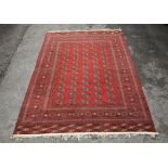 Persian red ground carpet with with five columns of medallions and multiple geometric decorative