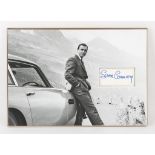 James Bond - Sean Connery signed page, mounted with a print of Connery with an Aston Martin DB5,