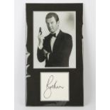 James Bond - Roger Moore signed display with photo showing him as 007, 10 x 18 inches.