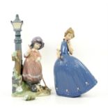 Two Lladro figures, girl standing by a lamp (foliage damaged), and girl in a blue dress holding a