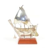 Silver white metal model of a boat on a stand