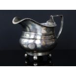 Silver bulbous form cream jug sat on four bull feet by Thomas Edward Atkins Birmingham 1915