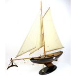 Contemporary model boat with sails mounted on oval stand