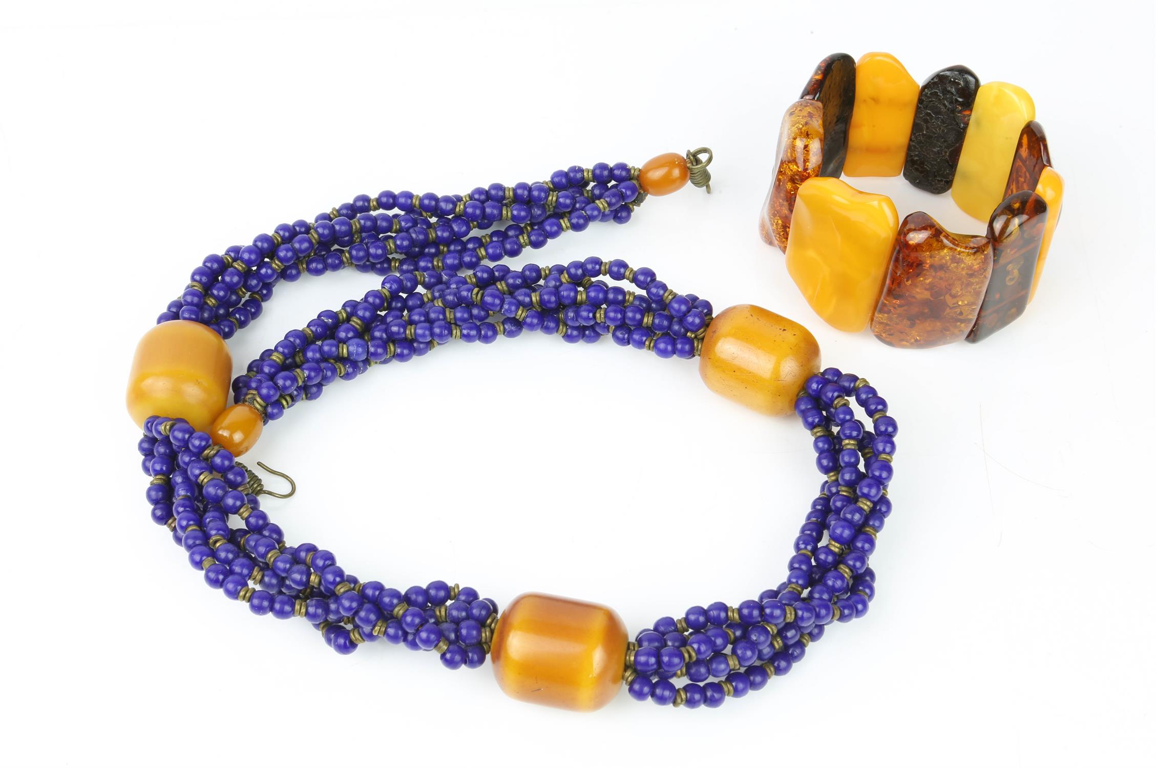 Three amber style necklaces including two amber bead necklaces, a resin and lapis bead necklace and