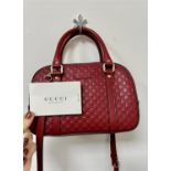 A soft red leather GUCCI crossbody embossed camera bag. Double top handle with detachable long