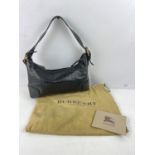 One black leather top handle BURBERRYS handbag with brass hardware and dust bag. Comes with