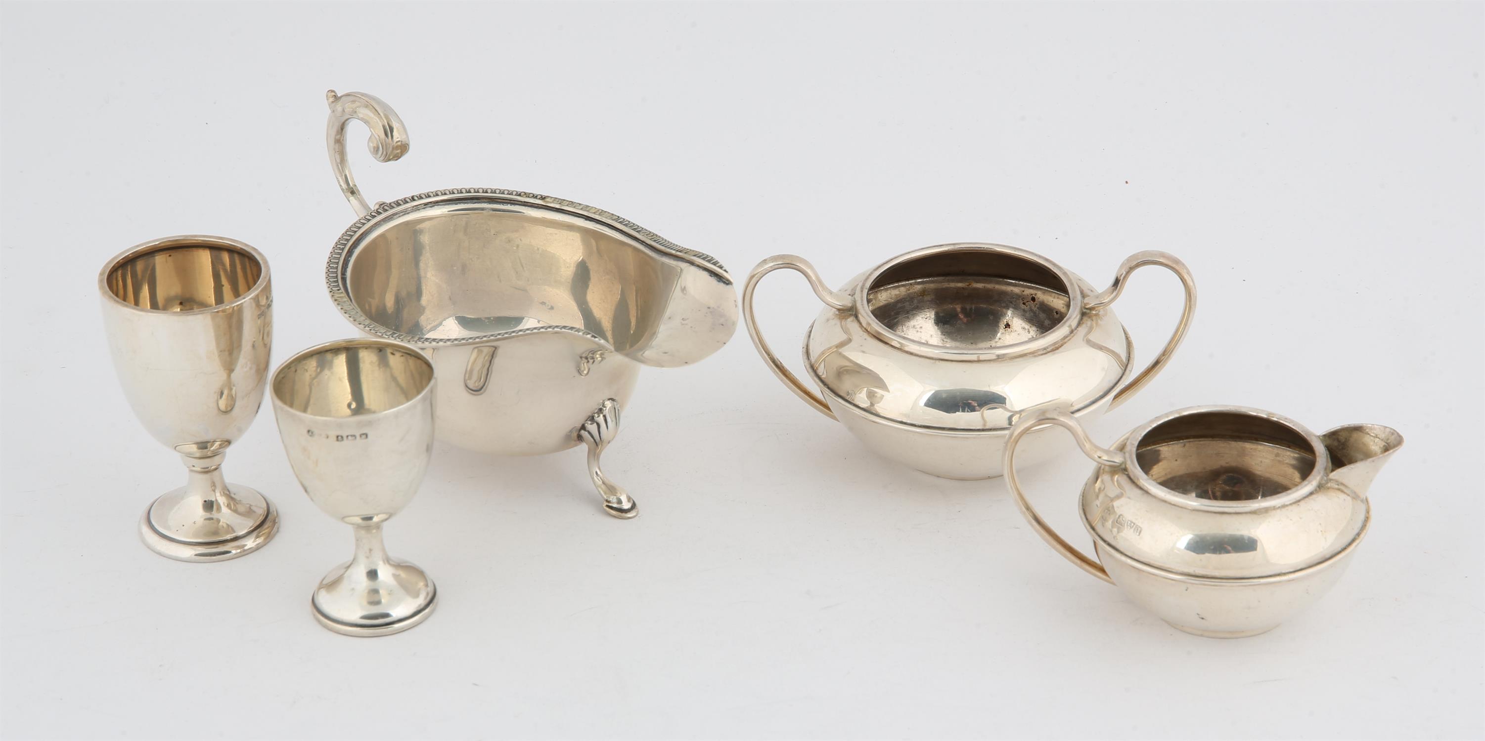 Five silver items, matching small sugar bowl and cream jug, two eggcups, and a sauceboat, 11.