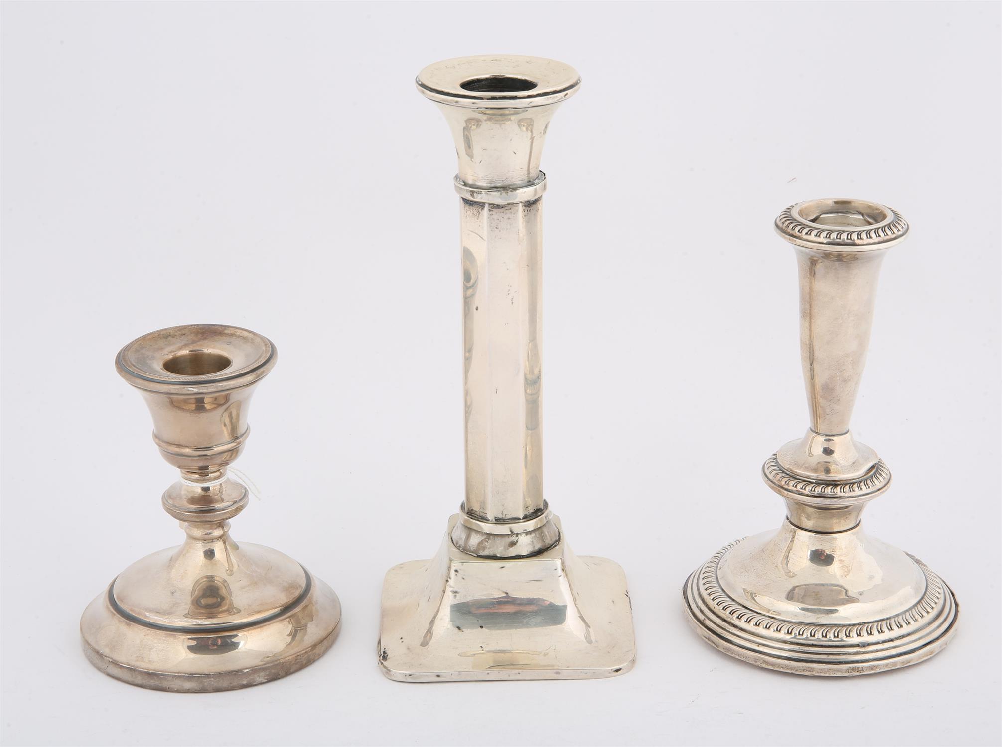 Sterling silver candlestick, 15 cms high, and two other English hallmarked candle sticks,