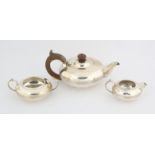 George V silver three piece round tea service Sheffield 1912, the teapot with wood handle and knob,
