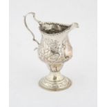 George III helmet shaped silver cream jug with embossed cottage, church and swan decoration,