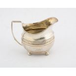 George III silver cream jug engraved band decoration and reeding on ball feet, London (marks rubbed