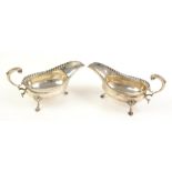 Pair of George III silver sauce boats with gadrooned borders on three hoof feet, maker's mark 'BM',