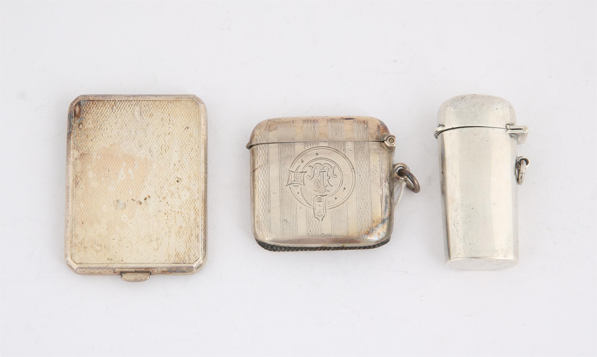 Engine turned silver vesta case, an engine turned card case, and a cigarette holder in silver case