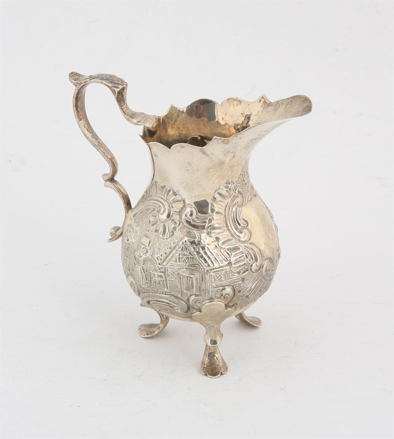 Victorian cream jug with embossed 18th century style decoration with cottages and figuresLondon