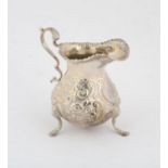 Silver cream jug, marks rubbed but probably George III, gadrooned border and embossed flower and