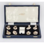 Set of eight Britannia standard silver menu holders two with snail finials, two with barrels,