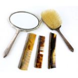 Silver backed dressing table items, comprising mirror, brush and three combs,