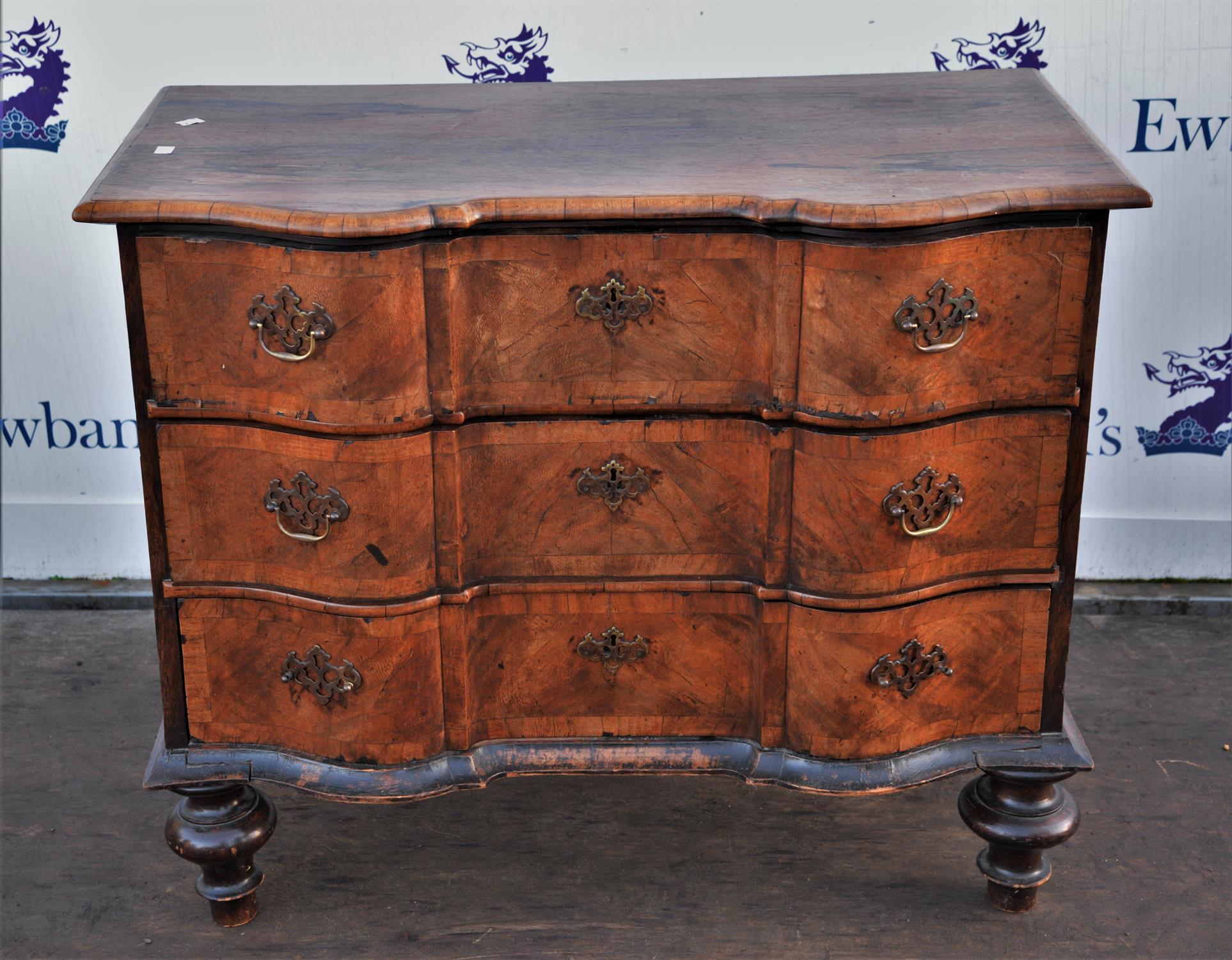 19th century rosewood shaped front three drawer chest with brass handles on raised turned legs,