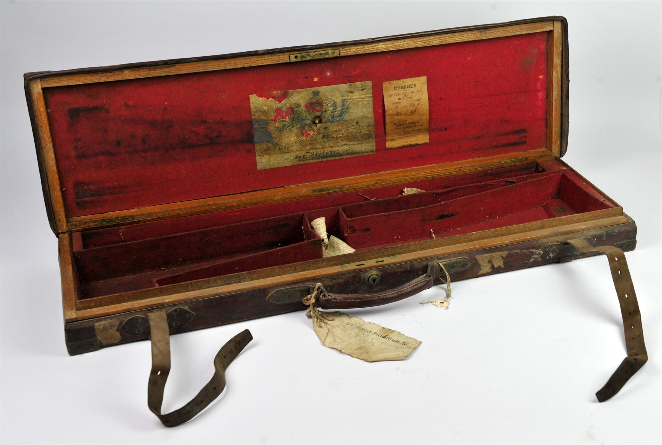 Leather bound oak gun case, with brass corners, the interior of the lid with a paper label for J.