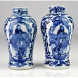 Matched pair of Chinese blue and white vases decorated with two panels of figures framed by