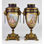 Pair of French Sevres style urns, 19th Century, with lion mask handles, on square bases with