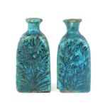 A pair of Raqqa style bottle vases; each one with unglazed base and decorated in black on the