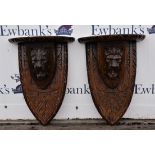 Pair of Continental oak corbels, with semi-circular plateaus, above lions mask and shield supports,