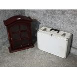 A wooden wall mounted cabinet and a hard case.