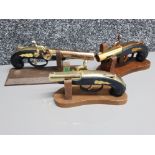 3 novelty flintlock pistol lighters all with wooden stands