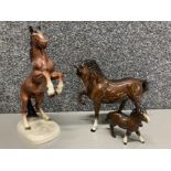 A Royal Doulton bay stallion and Shetland goal, together with a rearing stallion by another maker