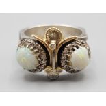 Silver and gold opal and diamond ornate ring, with two opals surrounded by diamonds and five