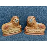 A pair of Staffordshire lions with glass eyes 25cm high