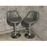 A pair of grey leatherette and metal breakfast bar stools