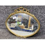 Gilt metal framed oval shaped mirror, with bow top design, 38x33cm