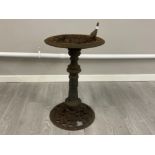 A cast iron bird bath with bird ornament