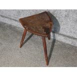 Three legged stool, the seat hand carved as a shield bearing coat of arms